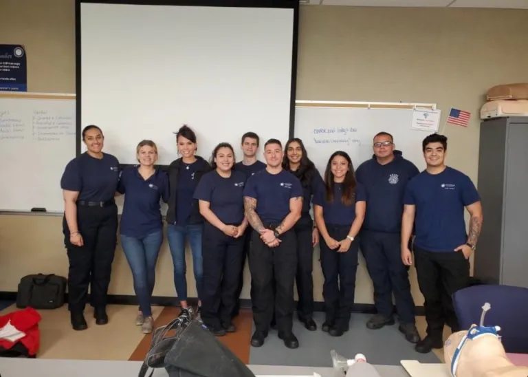 A group of EMTs standing together in a classroom after a training session